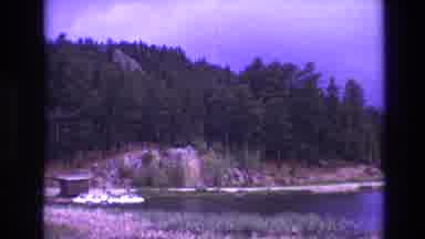 South Dakota USA (1974): Picturesque View Of A Tree-Lined Lake With Rocky Cliffs