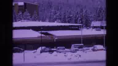 Vail Colorado USA (1974): Vehicles Driving By Snowy Building And Parking Lot On