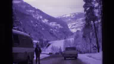Vail Colorado USA (1974): Cars Driving Down A Snowy Road Towards A Mountain
