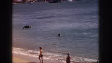 Hawaii USA (1959): Children Walk And Along A Beach While Others Swim Close To