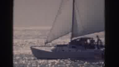Hawaii USA (1959): A Large Catamaran Sails Through Choppy Water Followed By People