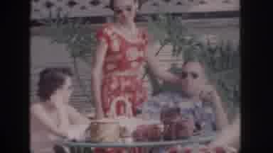 Hawaii USA (1959): Woman In Red Dress Standing By Man And Smiling In Sunglasses