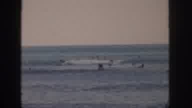 Hawaii USA (1959): A Surfer Rides The Waves At The Beach With People Swimming In