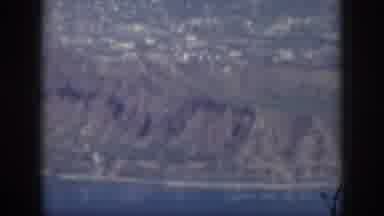 Oahu Hawaii USA (1959): Aerial View Of A Rocky, Mountainous Shoreline With A Town