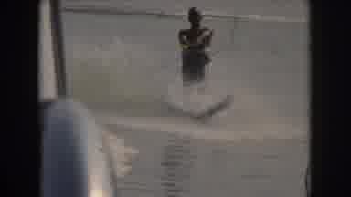 Grand Rapids Michigan USA (1961): Man On Water Skis Ski Alongside Boat On Smooth
