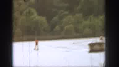 Michigan USA (1961): Water Skier Glides Across The Water Behind Leading Boat