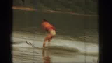 Michigan USA (1961): Man Water Skiing Behind A Boat On A Lake Near A Tree-Lined