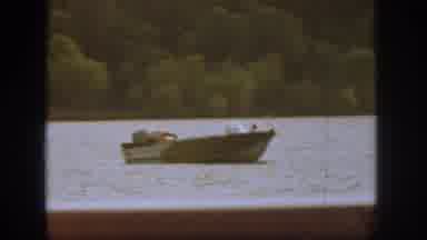 Michigan USA (1961): A Boat Floats By On The River With A Man Inside