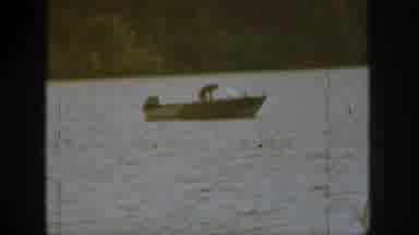 Michigan USA (1961): Man On A Boat In The Middle Of A Body Of Water Bending Down