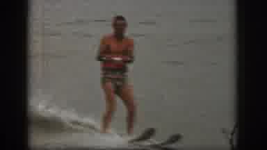 Michigan USA (1961): Man In Swim Trunks Skiing Across Lake Smiling Enjoying