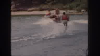 Michigan USA (1961): People In A Boat Watching As A Person In An Orange Life Vest