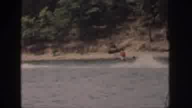 Michigan USA (1961): Man Water Skis At A Lake Near The Shore With Trees In The