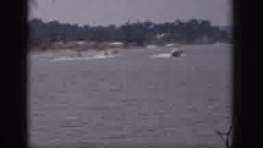 Michigan USA (1961): A Motorboat Creates A Wake As It Tows Two Skiers On A Lake