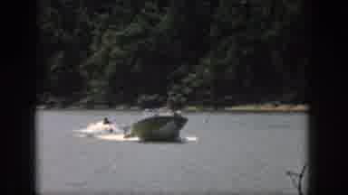 Michigan USA (1961): Speedboat Moves Along A Lake As A Man Rides On Water Skis