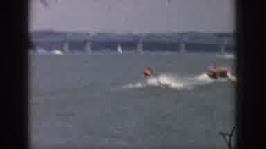 Michigan USA (1961): People Water-Ski On The Coastline Of A Large City With A