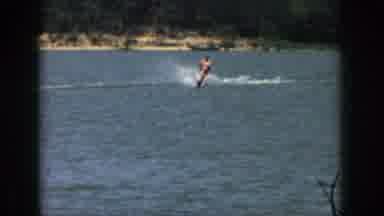 Michigan USA (1961): Man Skiing Behind Boat Near Lakeshore Making Waves In Water