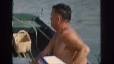 Michigan USA (1961): Man Steering The Motor Of A Small Boat On The Water