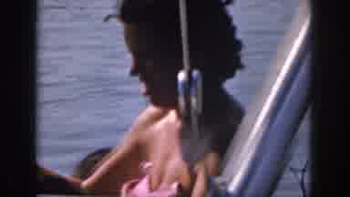 Michigan USA (1961): Small Family Boating And Skiing On Crowded Lake On Hot Day