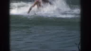 Michigan USA (1961): A Man Is Treading Water In A Wake And A Woman Is Water Skiing
