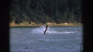 Michigan USA (1961): Man Surfing Quickly Across The Calm Lake Near A Cottage