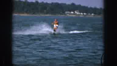 Michigan USA (1961): Tanned Man Wearing White Shorts Water-Skiing With Trees In