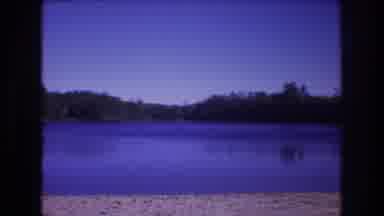 Baxter Maine USA (1975): View Of A Serene Lake And Far, Tree Covered Shoreline