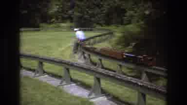Baxter Maine USA (1975): An Old Man Is Sitting On A Miniature Train Model Which