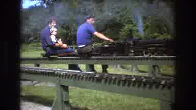 Baxter Maine USA (1975): Outside In Daytime Two Men And A Girl Sit On A Model
