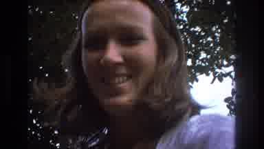 BAXTER MAINE USA-1975: Woman Smiling and Talking Outdoors with Trees