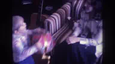 Baxter Maine USA-1975: Woman Sitting On Coach Giving Wrapped Gift To A Little Boy