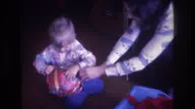 Baxter Maine USA (1975): Mom Helps Little Boy As He Tears Open His Christmas Gift