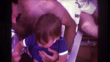 Boston USA (1975): A Young Child With His Father On A Beach In A Chair