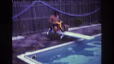 Boston USA (1975): A Man In Goggles Rides A Big Wheel Off Of A Diving Board