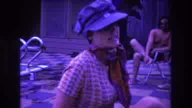 Boston USA (1975): Woman With Hat And Scarf In Front Of Man With A Towel Relaxing