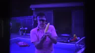 Boston USA (1975): Man Wearing Visor Stands Outside By Pool, He Holds A Corn On