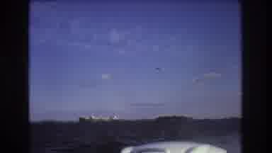 Boston USA (1975): A Jet Flies By A Motor Boat Going Through The Raging Waters Of