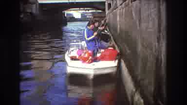 Boston USA (1975): People Standing In Boat With Poles, Sitting Child Parent Waves