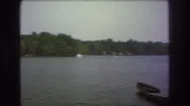 Boston USA (1975): A Group Of People Camping On The Shore Of A Lake