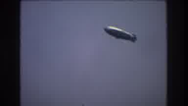 New York City USA (1976): A Blimp Flies Overhead While An Old World Ship Passes In