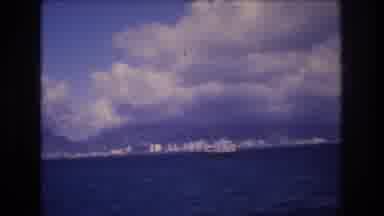 Honolulu Hawaii a USA (1977): Large Boat Sails Along The Coastline Of A Large City