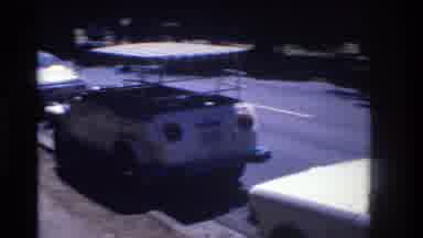 Honolulu Hawaii a USA (1977): Parked Small White Car Passed By A Large Yellow Bus