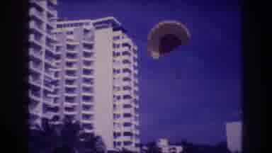 Acapulco Mexico (1982): Parasailor Sailing Past A Running Person And Dog Onto The