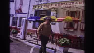 France (1967): Man Walking Past A Restaurant With A Child Looking On