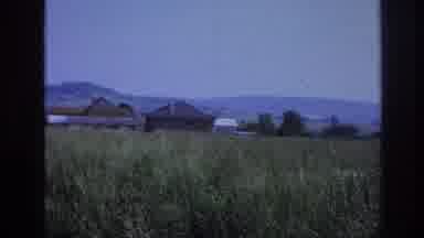 France (1967): Large Buildings Near Hilly Mountainside And Tall Grass On Clear Day
