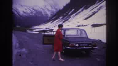 France (1967): Woman Walking Near A Car With Steep, Snowy Hillsides Nearby And A
