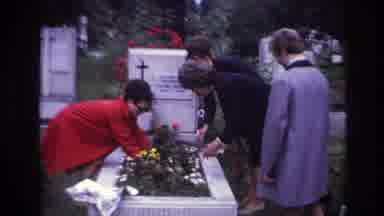 France (1967): People Visiting A Gravesite Fixing Flowers So That The Wind Will