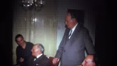France (1967): White Men Eating A Meal Together In Large Room With Table