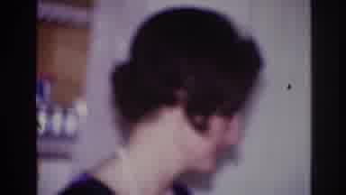 Ottawa Canada (1967): Woman Talking While Waving Hand At A Party While Man Walks