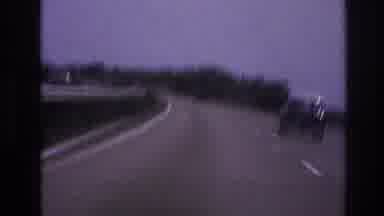 Paris France (1967): Several Cars Are Driving Along A Curved Stretch Of Paved Road
