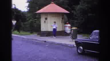 Paris France (1967): Woman In Blue Walks Away From Outdoor Toilets Carrying A Bag